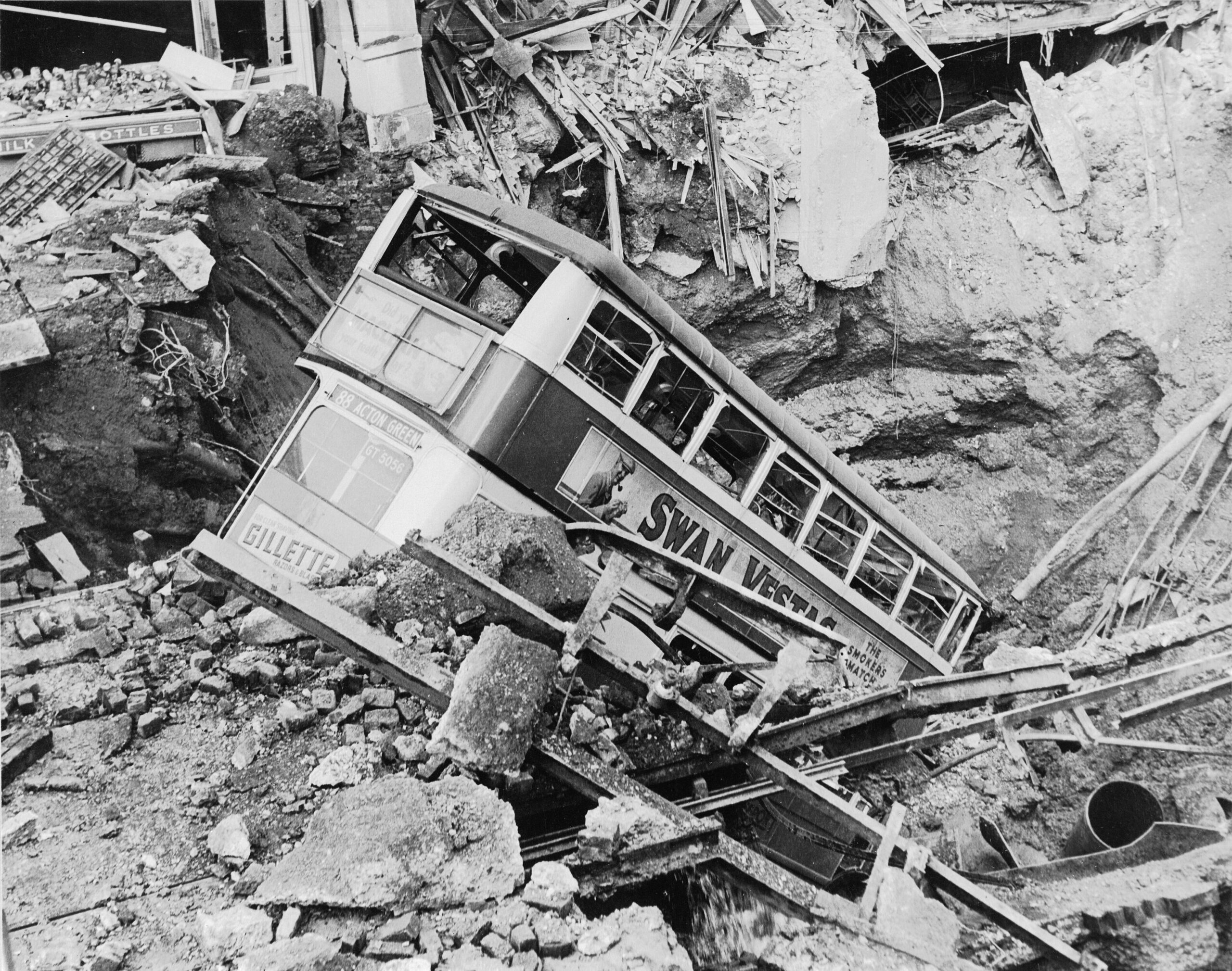A bus lies in the bomb crater above Balham Underground station, after the 14 October 1940 air raid.